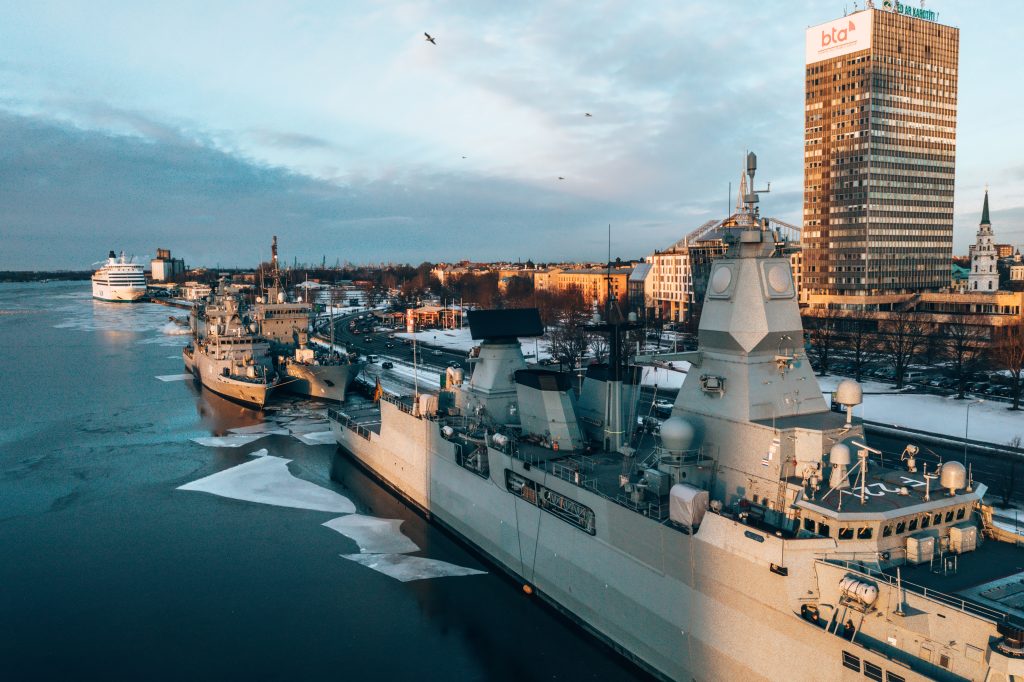 An aerial shot of big military ships in a harbor during winter