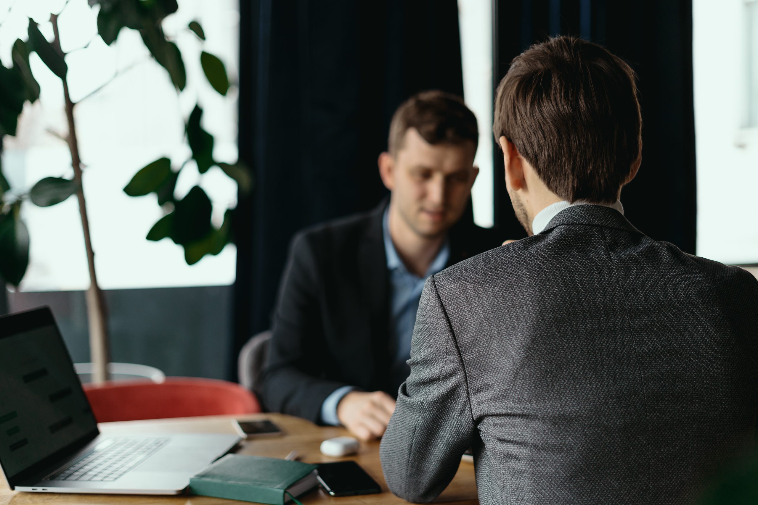 Two men working at laptop during a meeting